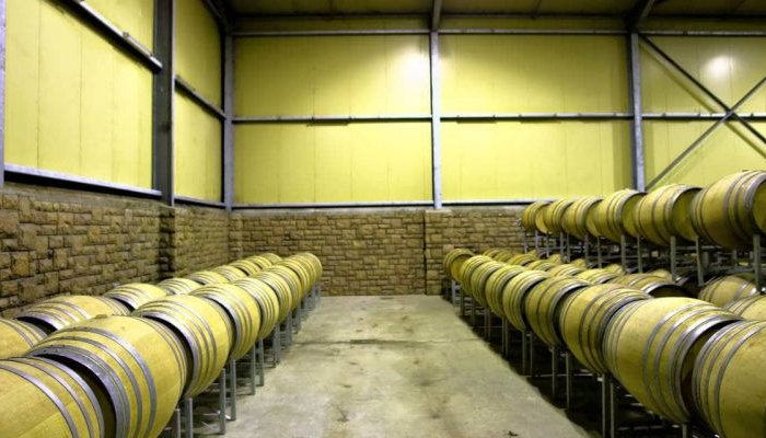 Rows of barrels in wine storage room. Shot in a wine farm between Stellenbosch and Cape Town, Western Cape, South Africa.